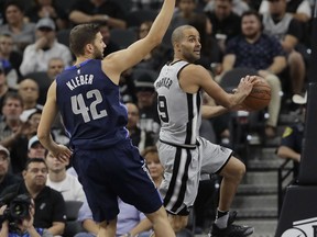 San Antonio Spurs guard Tony Parker (9) drives around Dallas Mavericks forward Maximilian Kleber (42) during the first half of an NBA basketball game, Monday, Nov. 27, 2017, in San Antonio. (AP Photo/Eric Gay)