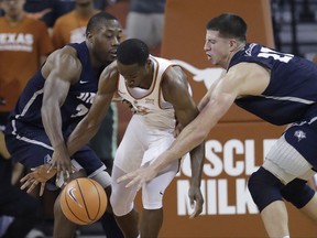 Texas guard Matt Coleman (2) is pressured by New Hampshire defenders Jacoby Armstrong, left, and Tanner Leissner during the first half of an NCAA college basketball game, Tuesday, Nov. 14, 2017, in Austin, Texas. (AP Photo/Eric Gay)