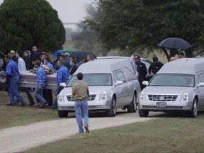 A casket is removed from one of two hearses during a grave side service for Richard and Therese Rodriguez at the Sutherland Springs Cemetery, Saturday, Nov. 11, 2017, in Sutherland Springs, Texas. The two were killed when a man opened fire inside the Sutherland Springs First Baptist church on Sunday. (AP Photo/Eric Gay)