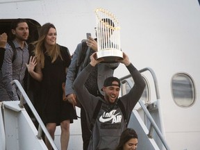 Houston Astros' George Springer arrives to Houston holding the Commissioner's Trophy, Thursday, Nov. 2, 2017, after winning the World Series against the Dodgers. (Marie D. De Jesus/Houston Chronicle via AP)