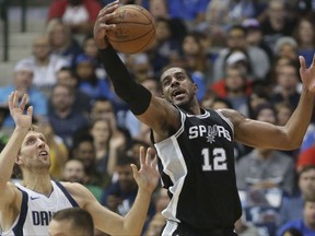 San Antonio Spurs forward LaMarcus Aldridge (12) grabs the ball in front of Dallas Mavericks forward Dirk Nowitzki (41), of Germany, during the first half of an NBA basketball game in Dallas, Tuesday, Nov. 14, 2017. (AP Photo/LM Otero)