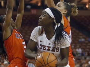 Texas forward Olamide Aborowa, center, looks to shoot against UTSA guard Alexus Dukes, left, and center Billie Marlow, right, during the first half of an NCAA college basketball game, Friday, Nov. 17, 2017, in Austin, Texas. (AP Photo/Michael Thomas)