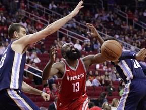 Houston Rockets guard James Harden (13) loses the ball on a drive to the basket under pressure from Memphis Grizzlies center Marc Gasol (33) and forward Dillon Brooks (24) during the second half of an NBA basketball game Saturday, Nov. 11, 2017, in Houston. (AP Photo/Michael Wyke)
