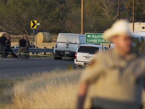Authorities work the scene where the suspect of a deadly church shooting was found dead in his vehicle, second left, partly seen in the background, near the intersection of FM 539 and Sandy Elm Road in Guadalupe County, Texas, Sunday, Nov. 5, 2017. The man opened fire inside of the First Baptist Church in Sutherland Springs, Texas, Sunday, killing more than 20 people. (William Luther/The San Antonio Express-News via AP)