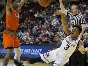 Texas A&M guard Admon Gilder (3) is fouled by Texas-Rio Grande Valley guard Nick Dixon (4) during the first half of an NCAA college basketball game Thursday, Nov. 30, 2017, in College Station, Texas. (AP Photo/Sam Craft)