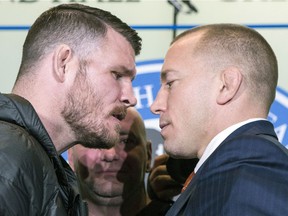 FILE - In this Oct. 13, 2017, file photo, Britain's Michael Bisping, left, and Canada's Georges St. Pierre face off during a news conference in Toronto, to promote their upcoming UFC 217.