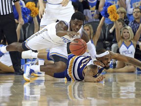 CSU Bakersfield guard/forward Shon Briggs (13) and UCLA guard Aaron Holiday (3) scramble on the floor in the first half of an NCAA college basketball game in Los Angeles, Wednesday, Nov. 29, 2017. (AP Photo/Reed Saxon)