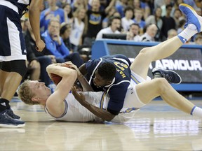 University of California Irvine, guard Max Hazzard (2) and UCLA center Thomas Welsh (40) battle on the floor in the first half of an NCAA college basketball game in Los Angeles Sunday, Nov. 26, 2017. (AP Photo/Reed Saxon)