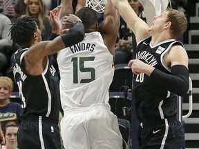 Utah Jazz forward Derrick Favors (15) gets between Brooklyn Nets forward Rondae Hollis-Jefferson (24) and center Timofey Mozgov (20) and dunks the basketball during the first quarter of NBA basketball game Saturday, Nov. 11, 2017, in Salt Lake City. (AP Photo/Chris Nicoll)