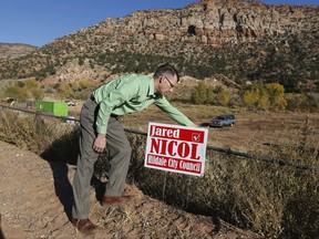 FILE - In this Oct. 26, 2017, file photo, Jared Nicol plants his campaign sign for city council in Hildale, Utah. In the Hildale council races unveiled Tuesday, Nov. 14, Maha Layton and Nicol won four-year seats while JVar Dutson won an election to fill the final two years for a councilman who left early. Two other members of the five-person council remain in place because they weren't up for re-election: Doran Jessop and Brian Jessop. (AP Photo/Rick Bowmer, File)