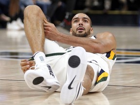 Utah Jazz center Rudy Gobert grabs his knee after being injured in the second half during an NBA basketball game against the Miami Heat, Friday, Nov. 10, 2017, in Salt Lake City. (AP Photo/Rick Bowmer)