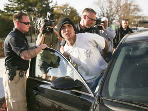 Austin Boutain, a suspect in Monday night's fatal shooting of University of Utah student ChenWei Guo, is led out of the University of Utah Department of Public Safety in Salt Lake City, Tuesday, Oct. 31, 2017. Boutain surrendered to police in Salt Lake City on Tuesday after a manhunt in the foothills near the University of Utah campus. Golden police say he's a person of interest in 63-year-old Mitchell Bradford Ingle's death. (Spenser Heaps/The Deseret News via AP)