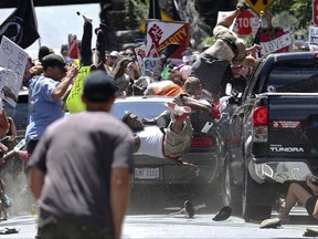FILE - In this Saturday, Aug. 12, 2017 file photo, people fly into the air as a vehicle drives into a group of protesters demonstrating against a white nationalist rally in Charlottesville, Va. Law enforcement agencies around the country are honing their responses to a string of rallies held by white nationalist groups as they struggle to balance free-speech rights with public safety. At the heart of the changes is a determination to prevent a repeat of the bloodshed resulting from a white nationalist rally in Charlottesville, Virginia, in August, when a car mowed down a counterprotester. (Ryan M. Kelly/The Daily Progress via AP, File)