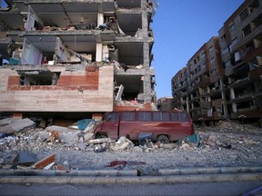 In this photo provided by the Iranian Students News Agency, ISNA, destroyed buildings and a car are seen after an earthquake at the city of Sarpol-e-Zahab in western Iran, Monday, Nov. 13, 2017. A powerful earthquake shook the Iran-Iraq border late Sunday, killing more than one hundred people and injuring some 800 in the mountainous region of Iran alone, state media there said. (Pouria Pakizeh/ISNA via AP)