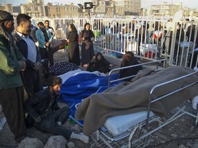 In this photo provided by Tasnim News Agency, relatives weep over the bodies of earthquake victims, in Sarpol-e-Zahab, western Iran, Monday, Nov. 13, 2017. Authorities reported that a powerful 7.3 magnitude earthquake struck the Iraq-Iran border region on Monday and killed more than three hundred people in both countries, sent people fleeing their homes into the night and was felt as far west as the Mediterranean coast. (Farzad Menati/Tasnim News Agency via AP)