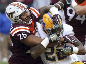 Virginia Tech's Andrew Motuapuaka (25) stops Pitt's Darrin Hall (22) at the line of scrimmage during the first half of an NCAA college football game in Blacksburg, Va. Saturday, Nov. 18 2017. (Matt Gentry/The Roanoke Times via AP)