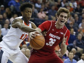 Wisconsin forward Nate Reuvers (35) and Virginia guard De'Andre Hunter (12) fight for a rebound during the first half of an NCAA college basketball game in Charlottesville, Va., Monday, Nov. 27, 2017. (AP Photo/Steve Helber)