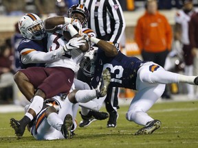 Virginia Tech running back Steven Peoples (32) gets wrapped up by Virginia linebacker Chris Peace (13) and safety Quin Blanding (3) during the first half of an NCAA college football game in Charlottesville, Va., Friday, Nov. 24, 2017. (AP Photo/Steve Helber)