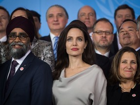 UNHCR Special Envoy Angelina Jolie, centre, stands with Defence Minister Harjit Sajjan, left, and Minister of Foreign Affairs Chrystia Freeland during the family photo with delegates at the 2017 United Nations Peacekeeping Defence Ministerial conference in Vancouver, B.C., on Wednesday November 15, 2017. THE CANADIAN PRESS/Darryl Dyck