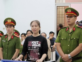 Nguyen Ngoc Nhu Quynh, center, a prominent Vietnamese blogger, stands trial in south central province of Khanh Hoa, Vietnam, Thursday, Nov. 30, 2017.