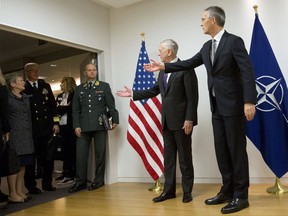 U.S. Secretary for Defense Jim Mattis, center, and NATO Secretary General Jens Stoltenberg, right, gesture to delegation members outside the room prior to a meeting on the sidelines of a NATO defense ministers meeting at NATO headquarters in Brussels on Wednesday, Nov. 8, 2017. NATO defense ministers start two days of talks looking to expand the military alliance's command structure and drum up more troop contributions for Afghanistan. (AP Photo/Virginia Mayo, Pool)