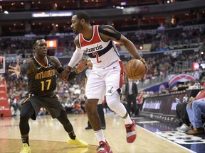 Washington Wizards guard John Wall (2) dribbles against Atlanta Hawks guard Dennis Schroder (17), of Germany, during the first half of an NBA basketball game, Saturday, Nov. 11, 2017, in Washington. (AP Photo/Nick Wass)