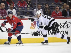 Los Angeles Kings right wing Dustin Brown (23) and Washington Capitals defenseman Dmitry Orlov (9), of Russia, watch the puck during the first period of an NHL hockey game, Thursday, Nov. 30, 2017, in Washington. (AP Photo/Nick Wass)
