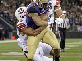 Washington's Myles Gaskin pulls a Utah defender with him as he scores on a 9-yard run during the first half of an NCAA college football game Saturday, Nov. 18, 2017, in Seattle. (AP Photo/Elaine Thompson)