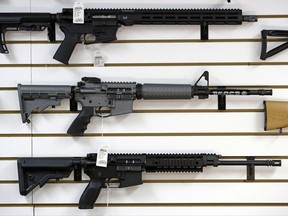 A Ruger AR-15 semi-automatic rifle, center, the same model, though in gray rather than black, used by the shooter in a Texas church massacre two days earlier, sits on display with other rifles on a wall in a gun shop Tuesday, Nov. 7, 2017, in Lynnwood, Wash. Gun-rights supporters have seized on the Texas church massacre as proof of the well-worn saying that the best answer to a bad guy with a gun is a good guy with a gun. Gun-control advocates, meanwhile, say the tragedy shows once more that it is too easy to get a weapon in the U.S. (AP Photo/Elaine Thompson)