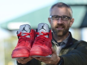 In this Thursday, Oct. 26, 2017 photo, The Rev. Joe DeScala of Mended, a non-denominational Christian church, holds up a pair of limited-edition Air Jordan athletic shoes in Port Angeles, Wash. DeScala and other community members purchased the shoes to replace those stolen from a 16-year-old Canadian tourist on Oct. 6. (Jesse Major/The Peninsula Daily News via AP)