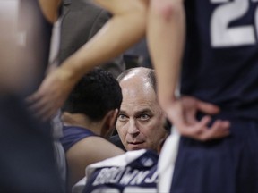 Utah State coach Tim Duryea, center, speaks with his players during a timeout in the first half of an NCAA college basketball game against Gonzaga in Spokane, Wash., Saturday, Nov. 18, 2017. (AP Photo/Young Kwak)