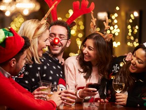 Group Of Friends Enjoying Christmas Drinks In Bar