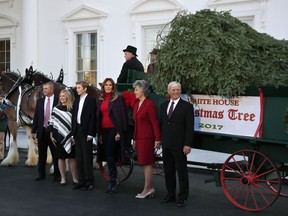 First lady Melania Trump, third from right, with her son Barron Trump, third from left, is presented by the Chapman family of Silent Night Evergreens, the Wisconsin-grown Christmas Tree at the North Portico of the White House in Washington, Monday, Nov. 20, 2017. The tree will be displayed in the White House Blue Room. (AP Photo/Manuel Balce Ceneta)
