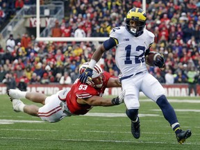 Michigan's Chris Evans (12) runs past Wisconsin's T.J. Edwards, left, during the first half of an NCAA college football game, Saturday, Nov. 18, 2017, in Madison, Wis. (AP Photo/Morry Gash)
