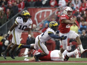 Wisconsin's Jonathan Taylor runs past Michigan's Josh Metellus during the second half of an NCAA college football game Saturday, Nov. 18, 2017, in Madison, Wis. (AP Photo/Morry Gash)