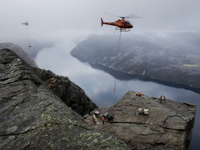 Equipment is airlifted by helicopters to Preikestolen (Pulpit Rock) in Lysefjorden near Stavanger, Norway, Friday Nov. 3, 2017, in preparation for filming of a new Mission Impossible movie.  The Pulpit rock rises 600 meters above the fjord and is a major tourist attraction, and the next Mission Impossible film is slated for release next year. (Carina Johansen/NTB scanpix via AP)