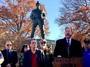 United Mine Workers of America environmental attorney Eugene Trisko speaks to a gathering of of miners in front of a statue of a coal miner, Tuesday, Nov. 28, 2017, at the state Capitol in Charleston, West Virginia. The union members held a news conference during a break in a public hearing on the Trump administration's planned repeal of an Obama-era plan to limit planet-warming carbon emissions. (AP Photo/John Raby)