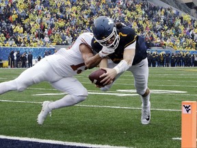 Texas defensive back Brandon Jones (19) tackles West Virginia quarterback Will Grier (7) short of the goal line during the first half of an NCAA college football game, Saturday, Nov. 18, 2017, in Morgantown, W.Va. Grier injured his hand in during the play and left the game. (AP Photo/Raymond Thompson)