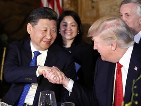 FILE - In this April 6, 2017 file photo, President Donald Trump, right, shakes hands with Chinese President Xi Jinping during a dinner at Mar-a-Lago, in Palm Beach, Fla. Trump begins a state visit to Beijing Wednesday. He'll be seeking Chinese action to rebalance its U.S. trade and to pressure on North Korea. Both presidents will then travel to Vietnam and the Philippines for regional summits, bidding for support among the continent's wavering leaders. (AP Photo/Alex Brandon)