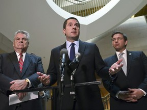 FILE - In this Oct. 24, 2017, file photo, House Intelligence Committee Chairman Rep. Devin Nunes, R-Calif., center, standing with Rep. Peter King, R-N.Y., left, and Rep. Ron DeSantis, R-Fla., right, speaks on Capitol Hill in Washington. As Congress returns from its Thanksgiving break, some Republicans would like to wrap up investigations into Russian meddling in the 2016 election that have dragged on for most of the year. But with new details in the probe emerging on an almost daily basis, that timeline seems unlikely. (AP Photo/Susan Walsh, File)