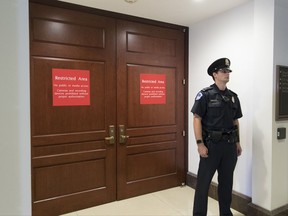 In this July 25, 2017 photo, a U.S. Capitol Police office stands guard outside a secure area in the basement of the Capitol in Washington, where the House Intelligence Committee has been conducting interviews. The House intelligence committee is preparing to interview Russian-American lobbyist Rinat Akhmetshin, who attended a meeting at Trump Tower last year with President Donald Trump's son, and Attorney General Jeff Sessions, according to people familiar with the interviews. (AP Photo/J. Scott Applewhite)
