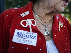 In this Nov. 17, 2017 photo, an Alabama resident attends a news conference in Montgomery, Ala. President Donald Trump will not campaign for Republican Alabama Senate candidate Roy Moore before the Dec. 12 special election, a White House official said Monday.  (AP Photo/Brynn Anderson)