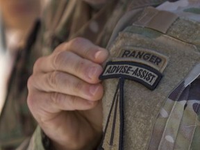 In this Oct. 17, 2017, photo, U.S. Army Col. Scott Jackson shows the patch for the Army's new Security Force Assistance Brigade as they train at Ft. Benning in Columbus, Ga. Jackson commands the brigade that is scheduled to deploy to Afghanistan next year to help train and advise Afghan forces. The Army's new training brigade is looking beyond traditional best practices to see if soldiers meet the cultural and personality criteria to train local forces in dramatically different cultures. (AP Photo/John Bazemore)