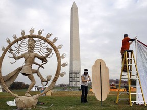 Jaye Brotherton of Jamestown, Colo., center, and Ben Harper, right, work on installation of the "Nataraja" artwork for Catharsis on the Mall, Thursday, Nov. 9, 2017, an event that plans to bring a taste of Burning Man to the National Mall in Washington. The "Nataraja" was a part of last year's TransFOAMation Camp at Burning Man. The Catharsis on the Mall event begins Friday afternoon and continues through Sunday with round-the-clock, seminars and performances in tents, stages and camps built near the foot of the Washington Monument. (AP Photo/Jacquelyn Martin)