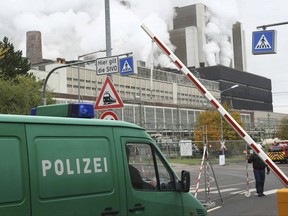 Police vehicles driving into the premises of the Weisweiler coal-fired power plant near Aachen, Germany, Wednesday  Nov. 15, 2017. According to German dpa news agency environmental activists on Wednesday occupied  coal supply routes of the Weisweiler coal-fired power plant.  (Ralf Roeger/dpa via AP)