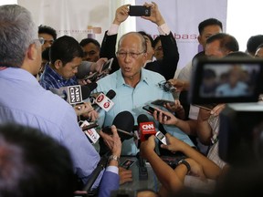 Philippine Secretary of National Defense Delfin Lorenzana answers questions from media in Makati, metropolitan Manila, Philippines, Wednesday, Nov. 8, 2017. Lorenzana says President Rodrigo Duterte has stopped construction work on a newly formed sandbar in the disputed South China Sea after a protest from Beijing. (AP Photo/Aaron Favila)