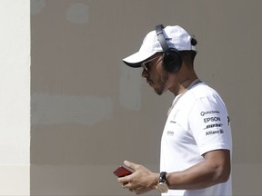 Mercedes driver Lewis Hamilton of Britain walks in the paddock before the first free practice at the Yas Marina racetrack in Abu Dhabi, United Arab Emirates, Friday, Nov. 24, 2017. The Emirates Formula One Grand Prix will take place on Sunday. (AP Photo/Luca Bruno)