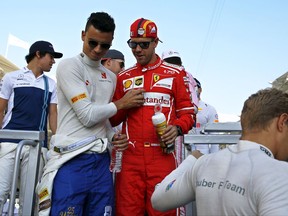 Sauber driver Pascal Wehrlein and Ferrari driver Sebastian Vettel, center right, both of Germany, step down the drivers' parade truck platform before the Emirates Formula One Grand Prix at the Yas Marina racetrack in Abu Dhabi, United Arab Emirates, Sunday, Nov. 26, 2017. (AP Photo/Hassan Ammar)