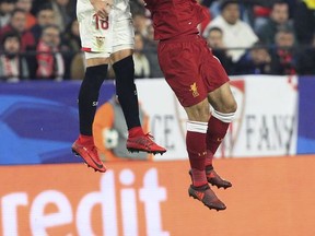 Liverpool's Mohamed Salah jumps for the ball with Sevilla's Sergio Escudero,left, during a Champions League group E soccer match between Sevilla and Liverpool, at the Ramon Sanchez Pizjuan stadium in Seville, Spain, Tuesday, Nov. 21, 2017. (AP Photo/Miguel Morenatti)