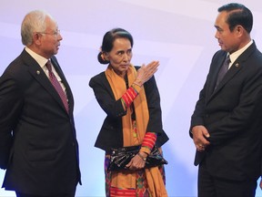 Myanmar's State Counsellor and Foreign Minister Aung San Suu Kyi, center, gestures while talking to Thailand's Prime Minister Prayut Chan-o-Cha, right, and Malaysia's Prime Minister Najib Razak during the 20th ASEAN-China Summit in metro Manila, Philippines Monday Nov. 13, 2017. (Romeo Ranoco/Pool Photo via AP)